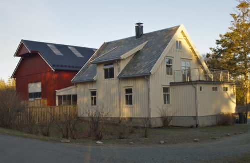 Austrått, Austrått Agroturisme, hvitt hus med glassveranda , skifertak, rød låve til venstre