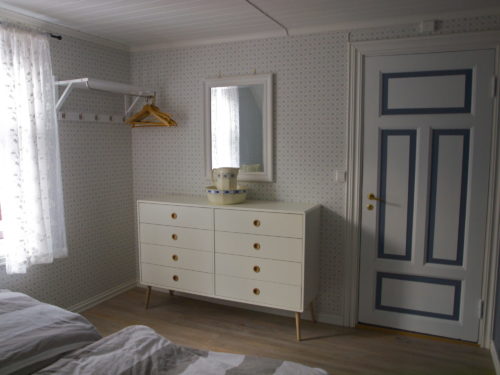 Austrått agroturisme, Kårstua, soverom med blå og hvite farger, hvit kommode med speil over.