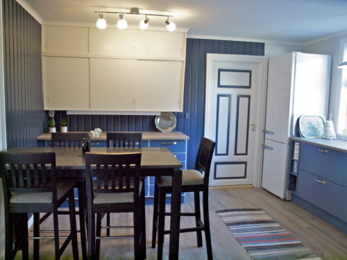 Austrått agroturisme, Kårstua, kjøkken med blå innredning, høyt bord med svarte barkrakker, blå vegger
